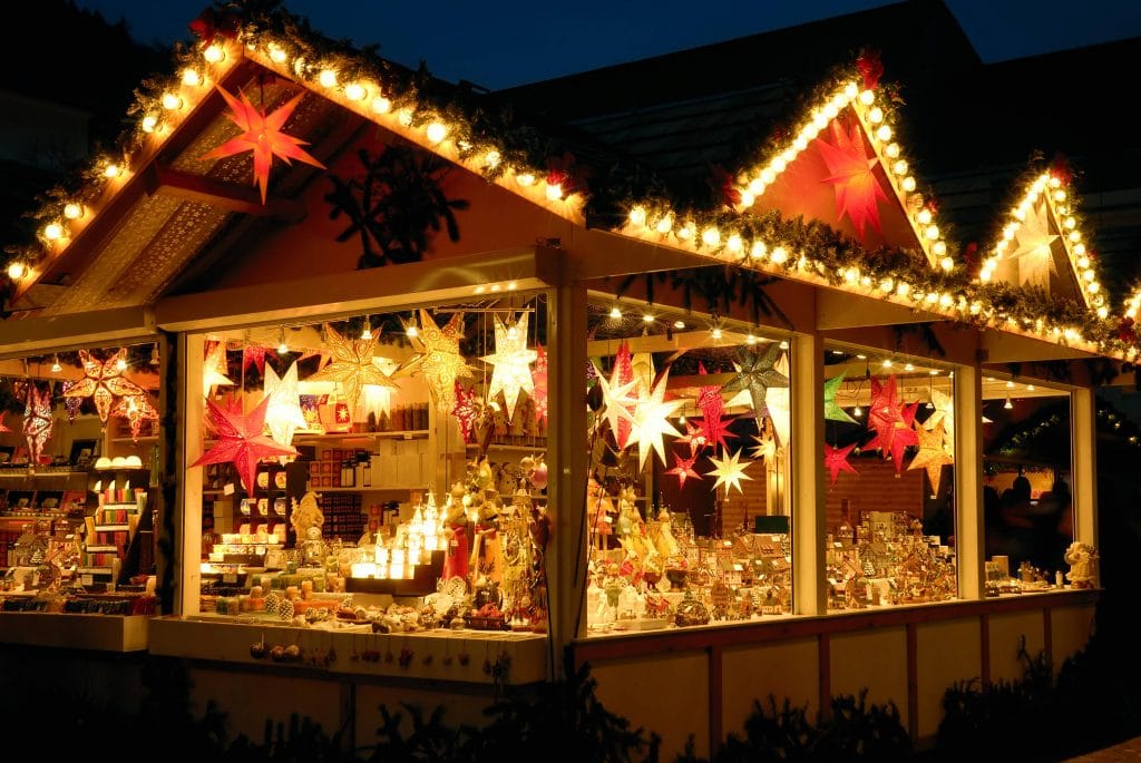 A stall at a Christmas market, decorated with red and gold stars. 