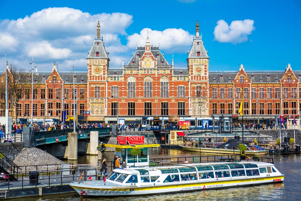 A view of Amsterdam Central Station with the river in front of it.