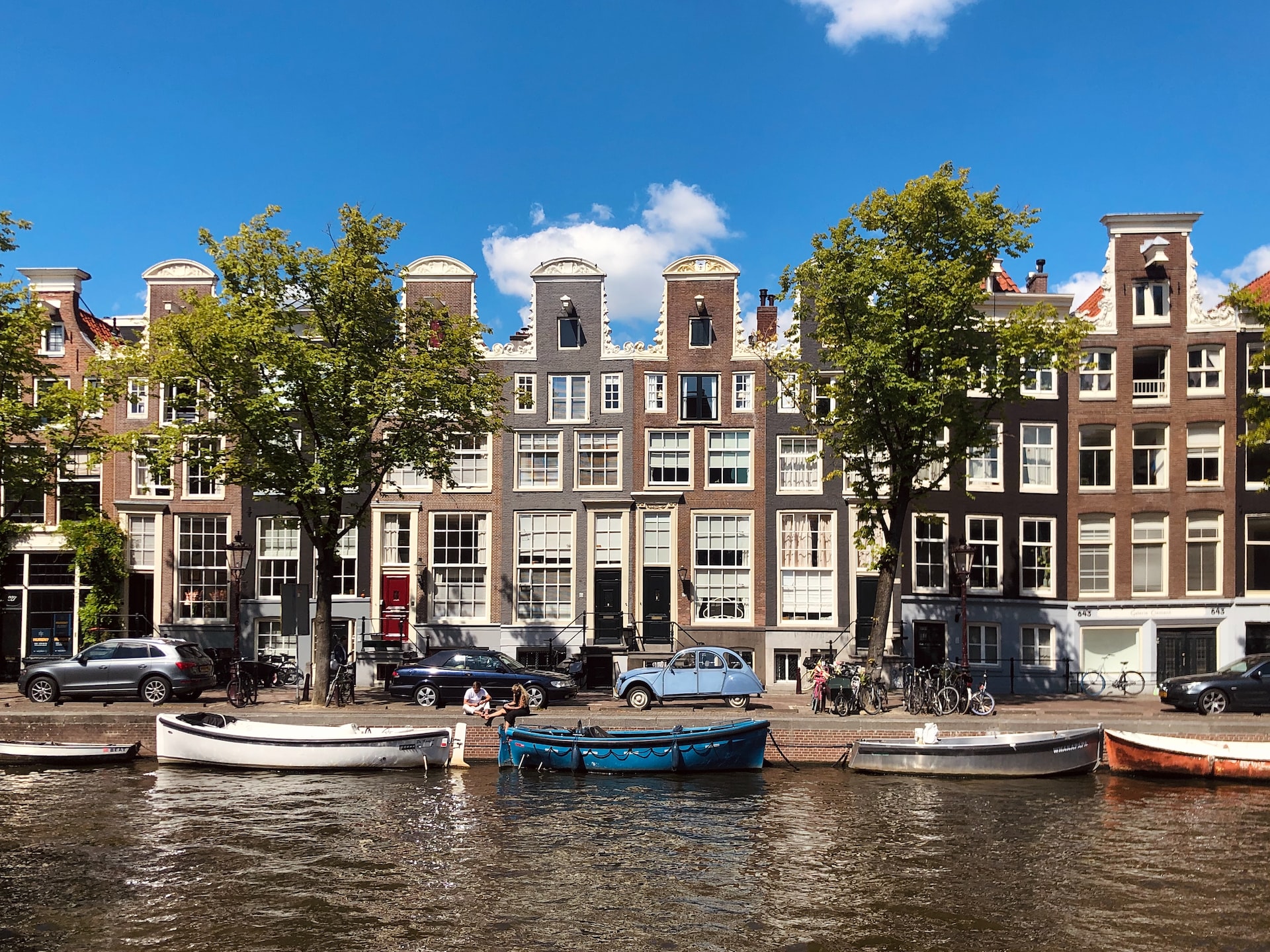 Houses and boats sit alongside a canal in Amsterdam.
