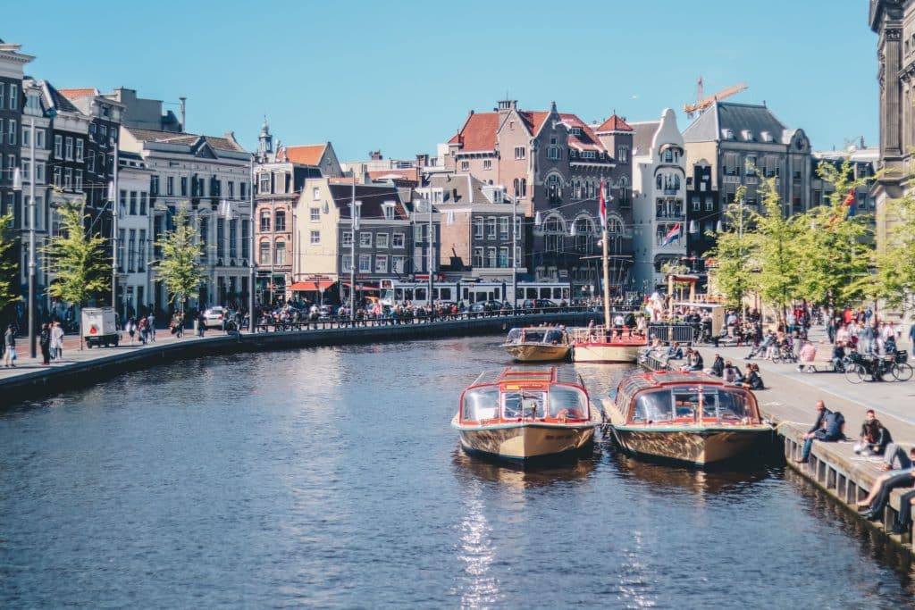 One of Amsterdam's canals lined with boats on a sunny day.