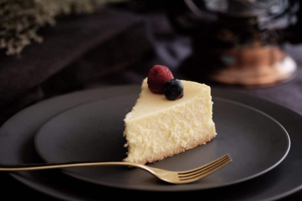A slice of vanilla cheesecake topped with berries.